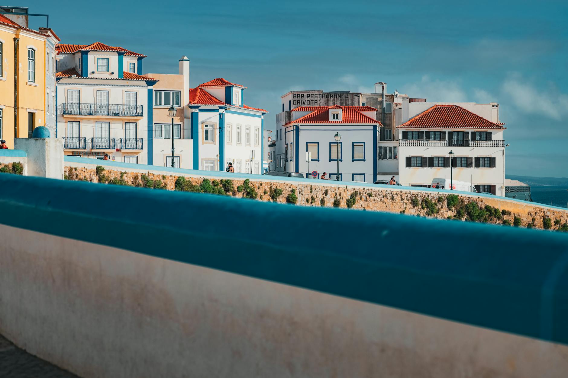 Kolorowe domy i dachy nad oceanem w nadmorskim miasteczku Ericeira