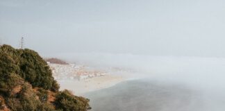 Mglista plaża i wybrzeże Nazaré w Portugalii z lotu ptaka