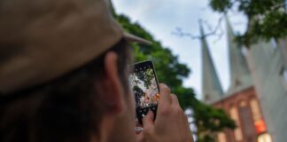 Osoba fotografuje wieże kościoła w Berlinie smartfonem
