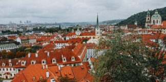 Panorama czerwonych dachów i zabytkowych kamienic w centrum Pragi