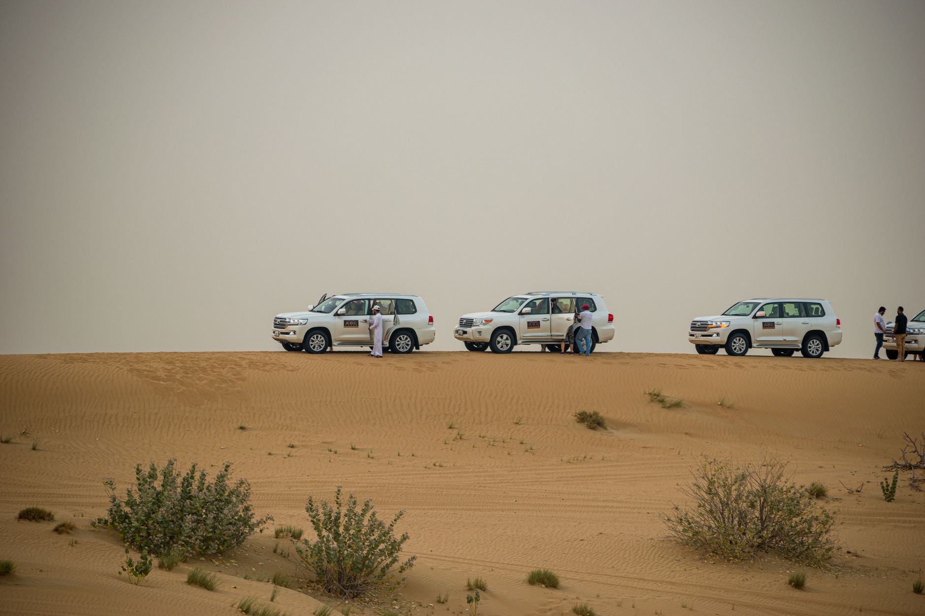 Białe SUV-y podczas pustynnego safari na wydmach w Dubaju
