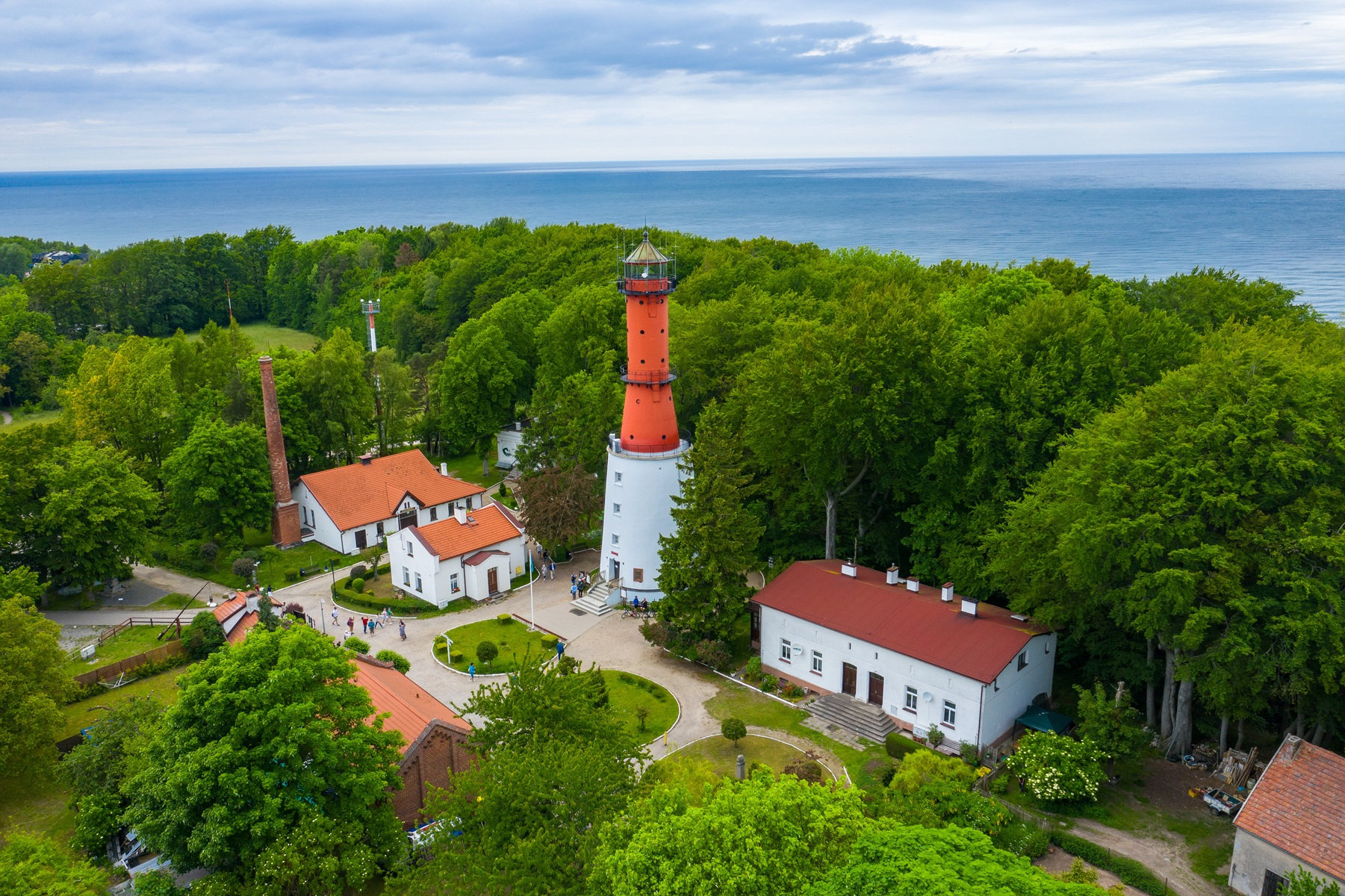 Zachód słońca nad Bałtykiem z widoczną latarnią morską w Rozewiu - inspiracja gdzie na wakacje w Polsce 2026