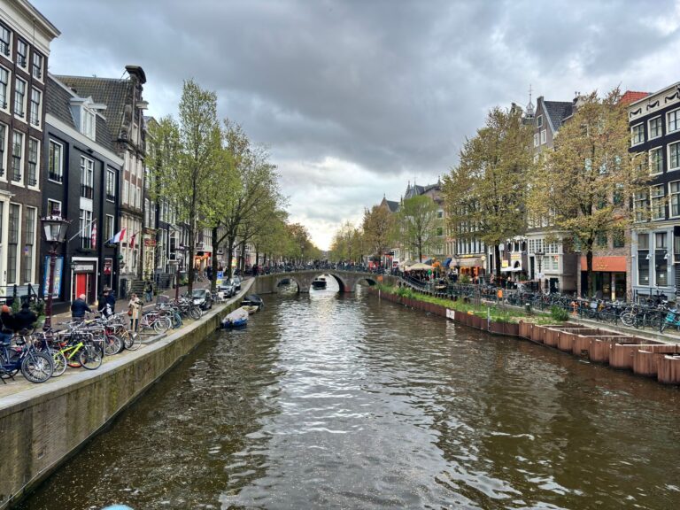 Kanał w Amsterdamie z tradycyjną zabudową i rowerami nad wodą