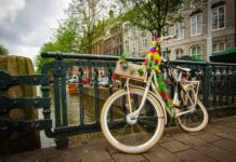 Rower ozdobiony kwiatami przy moście nad kanałem w Amsterdamie