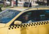 Lotnisko w Budapeszcie – jak dojechać do centrum autobusem, metrem lub taksówką? Kierowca żółtej taksówki na ulicy Budapesztu